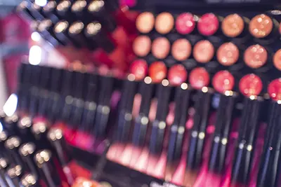 Closeup of a makeup store display featuring various shades of lipstick
