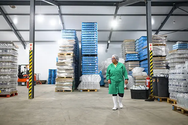 Temperature-controlled warehouse with stacked pallets of packaged products, showcasing industrial refrigeration and cold storage solutions.
